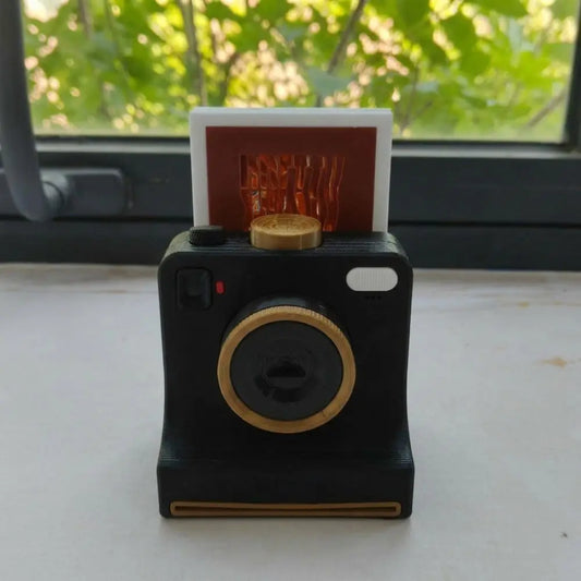 Black CremaCam vintage-style camera with a stencil card on top
